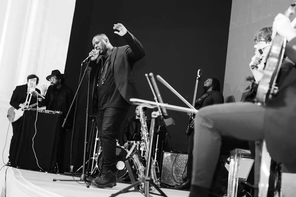 man in black talking on a microphone