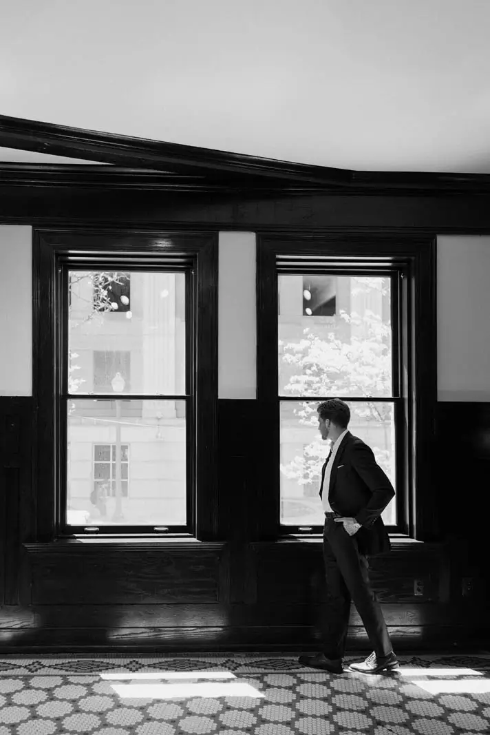 man in suit looking out the window